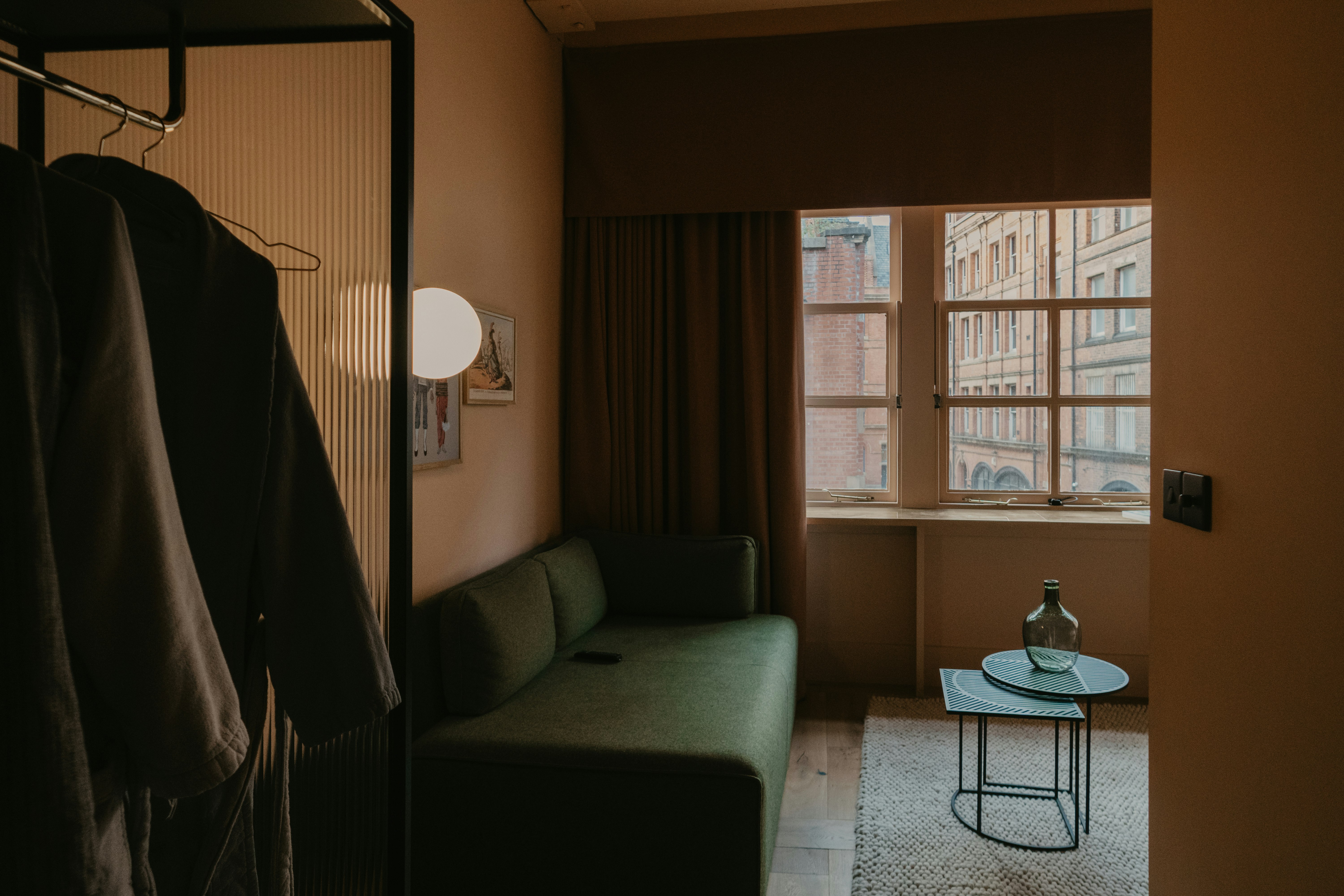 gray sofa near brown window curtain